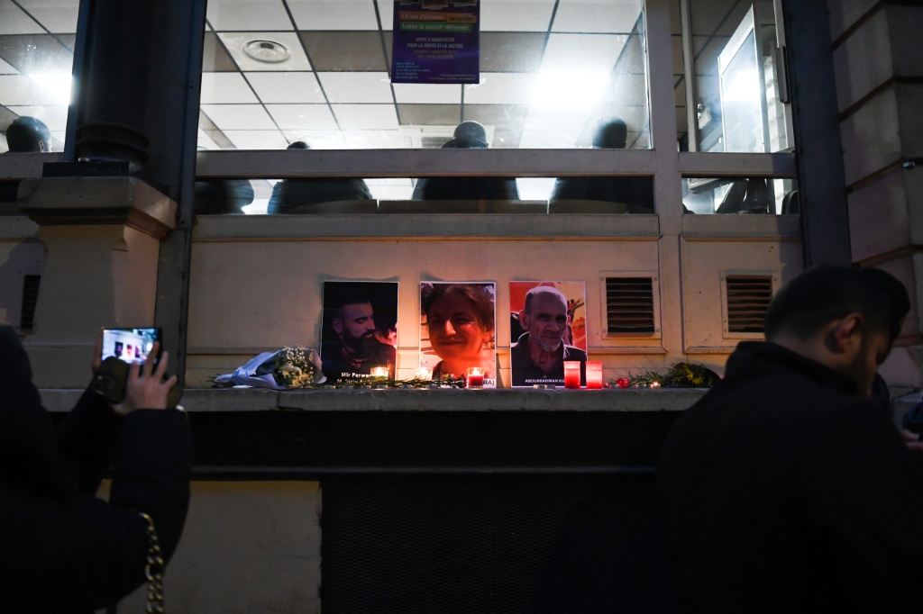 صورة التقطت في 24 كانون الأول/ديسمبر 2022 تظهر شموع تكريم وصور لضحايا إطلاق النار الثلاث أمام "المركز الديموقراطي الكردستاني" في باريس (أ ف ب)