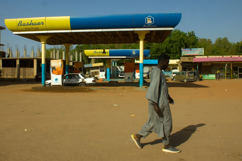     رجل يمر من أمام محطة بنزين مغلقة في مدني ، جنوب شرق العاصمة السودانية الخرطوم (أ ف ب)