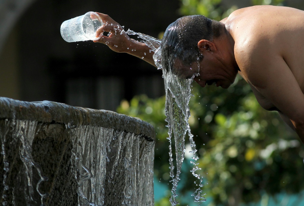 رجل يصب المياه على رأسه اتقاء من الحر في غوادالاخارا في المكسيك التي تشهد موجة قيظ في 12 حزيران/يونيو 2023 (ا ف ب)