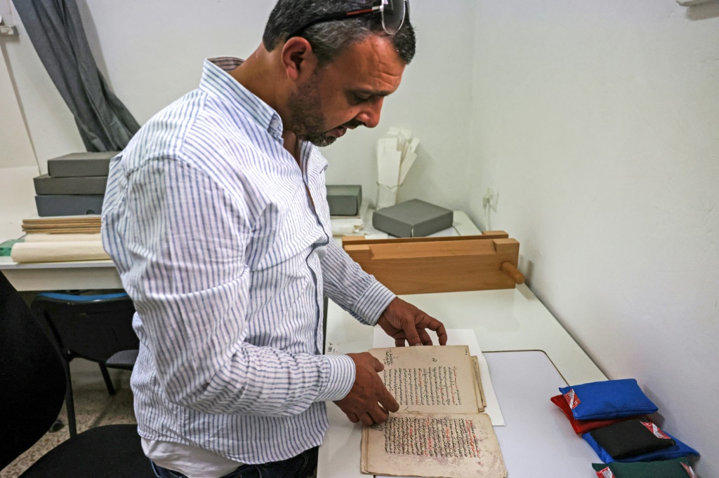 صورة مؤرخة في 17 حزيران/يونيو 2023 للخبير رامي سلامة في معمل ترميم في المكتبة الخالدية في القدس (ا ف ب)