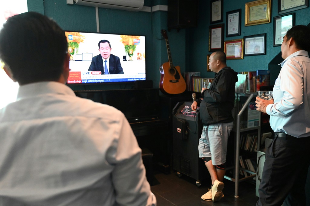 كمبوديون يتابعون عبر شاشة التلفزيون كلمة لرئيس الوزراء هون سين يعلن فيها تنحيه عن الحكم في 26 تموز/يوليو 2023 (ا ف ب)