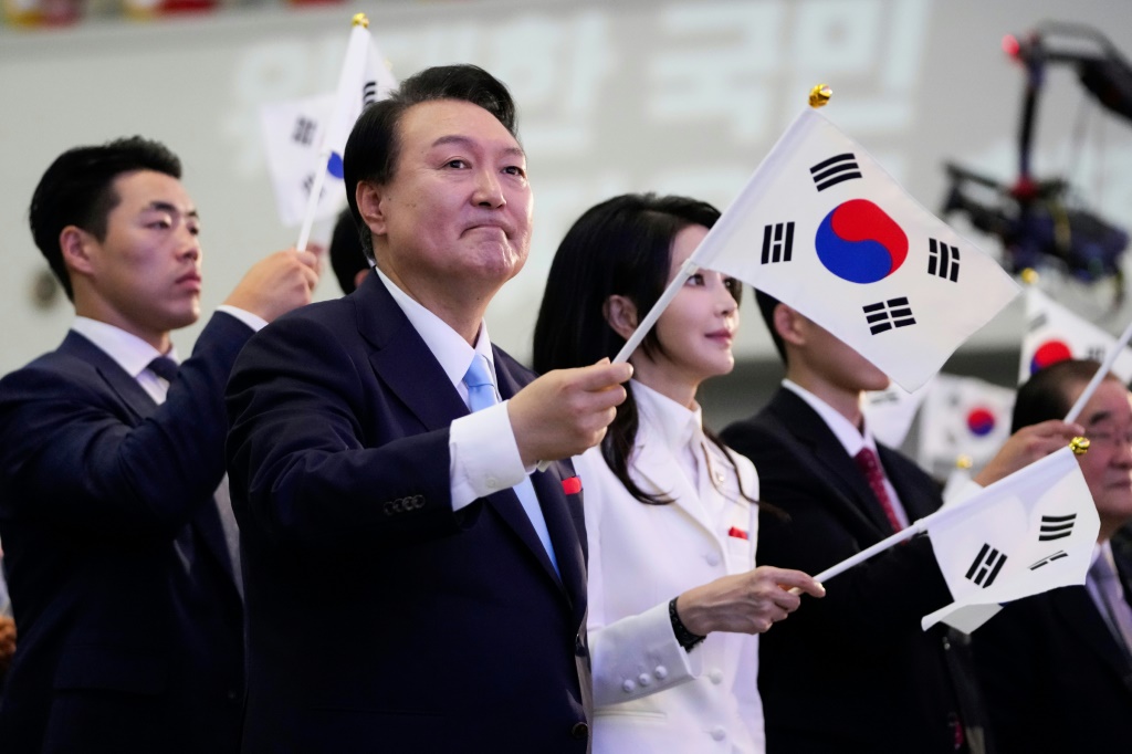 الرئيس الكوري الجنوبي يون سوك يول يلوّح بعلم بلاده خلال احتفال بـ"يوم التحرير" من الاحتلال الياباني في 15 آب/أغسطس 2023 (ا ف ب)