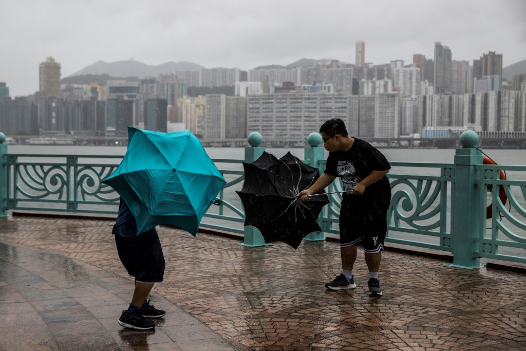 شابان يعانيان في حمل مظلّتَيهما بسبب الرياح القوية المرفقة للإعصار الكبير ساولا في هونغ كونغ في الأول من أيلول/سبتمبر 2023 (ا ف ب)
