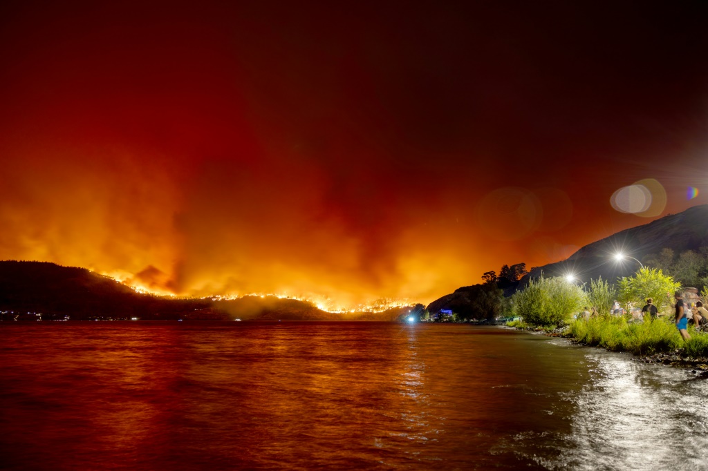 سكان من كيلونا ينظرون إلى حريق في خليج ماكدوغال كريك في مقاطعة بريتيش كولومبيا الكندية في 17 آب/أغسطس 2023 (ا ف ب)