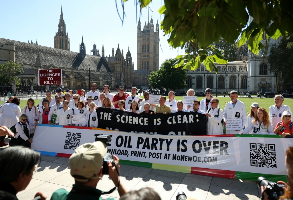 علماء يحملون لافتات تطالب بإنهاء منح الحكومة تراخيص جديدة لإنتاج النفط والغاز في المملكة المتحدة، بالقرب من البرلمان في وسط لندن في 4 أيلول/سبتمبر 2023 (ا ف ب)