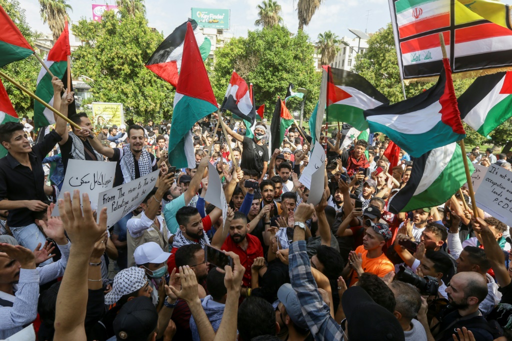 سوريون يحملون الأعلام الفلسطينية والسورية خلال مشاركتهم في وقفة تضامنية في 10 تشرين الأول/أكتوبر 2023 في ساحة عرنوس في وسط دمشق، تضامناً مع الشعب الفلسطيني (ا ف ب)