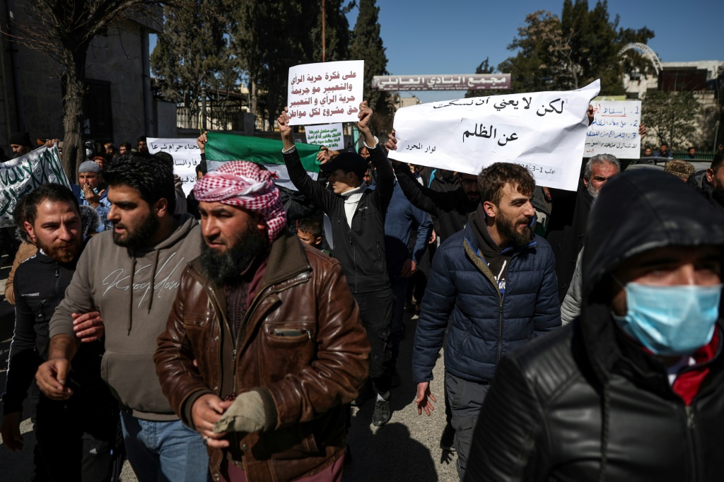 متظاهرون يسيرون عبر مدينة إدلب السورية في احتجاج نادر ضد هيئة تحرير الشام، التابعة لتنظيم القاعدة السابق، والتي تسيطر على جزء كبير من شمال غرب البلاد. (أ ف ب)   