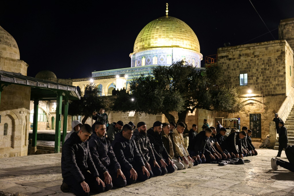 مصلون يؤدون صلاتي العشاء والتراويح في باحات المسجد الأقصى في البلدة القديمة من القدس الشرقية المحتلة في اليوم الاول من شهر رمضان في 11 آذار/مارس 2024 (ا ف ب)