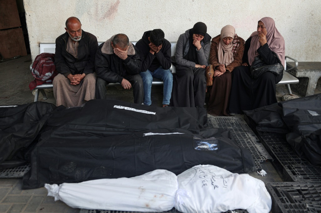 فلسطينيون يبكون أمام جثث أفراد من عائلتهم قتلوا في القصف الإسرائيلي خلال الليل، في مستشفى النجار في رفح بجنوب قطاع غزة في 25 آذار مارس، 2024 (ا ف ب)
