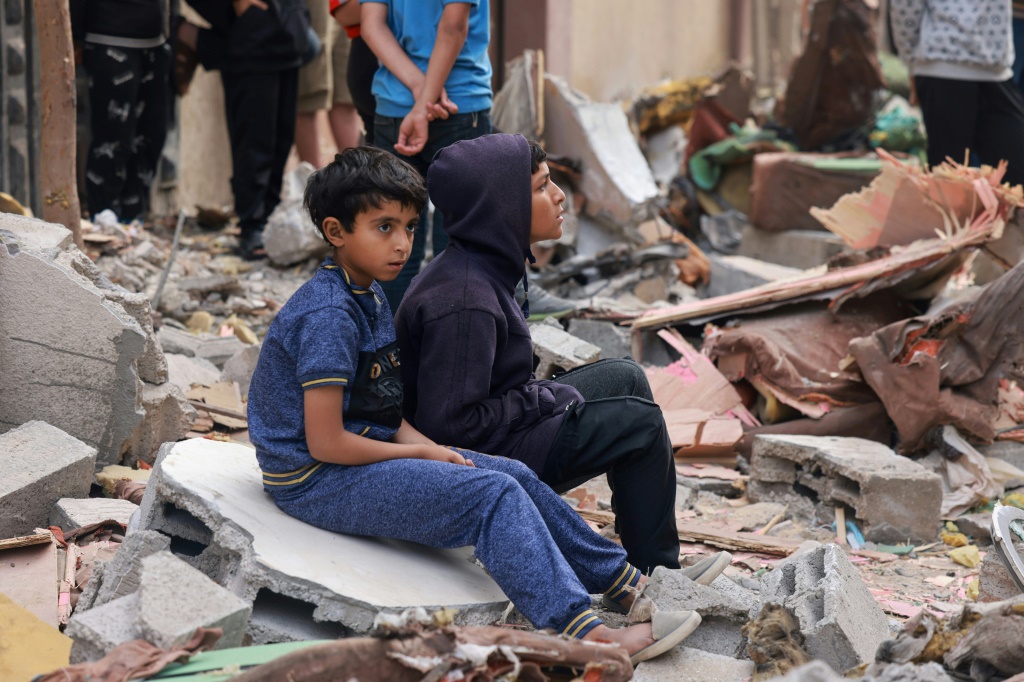 أطفال فلسطينيون على أنقاض مبنى دمر جراء قصف إسرائيلي في رفح بجنوب قطاع غزة في 4 نيسان/أبريل 2024 (ا ف ب)