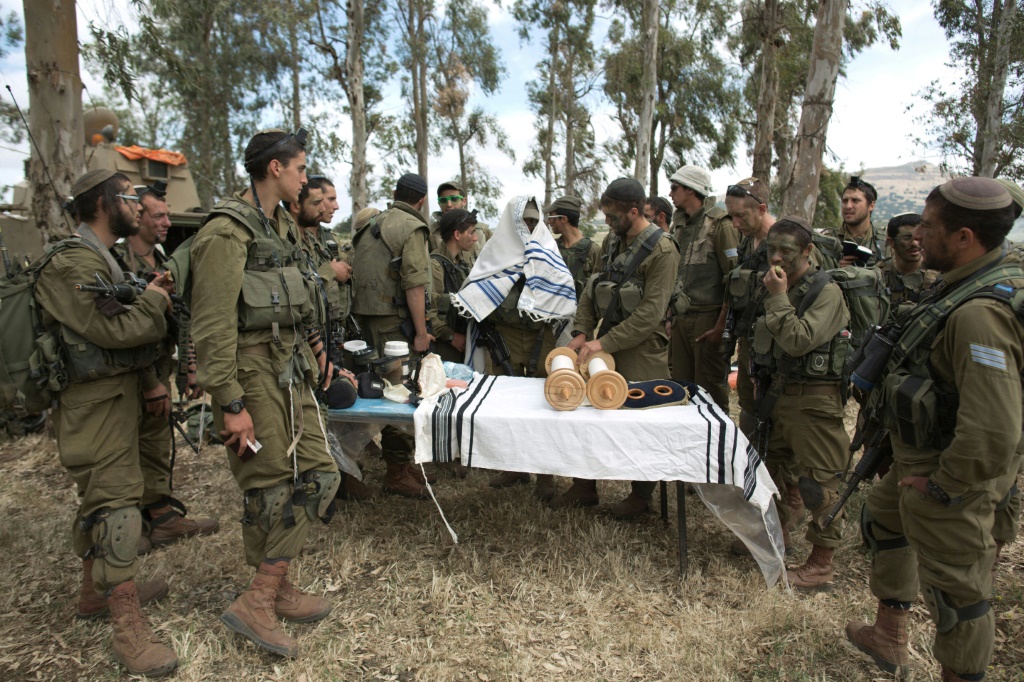 جنود إسرائيليون من كتيبة "نيتساح يهودا" يؤدون صلاة الصباح أثناء مشاركتهم في تدريب وحدتهم السنوي في مرتفعات الجولان التي ضمتها إسرائيل بالقرب من الحدود السورية في 19 أيار/مايو 2014 (ا ف ب)