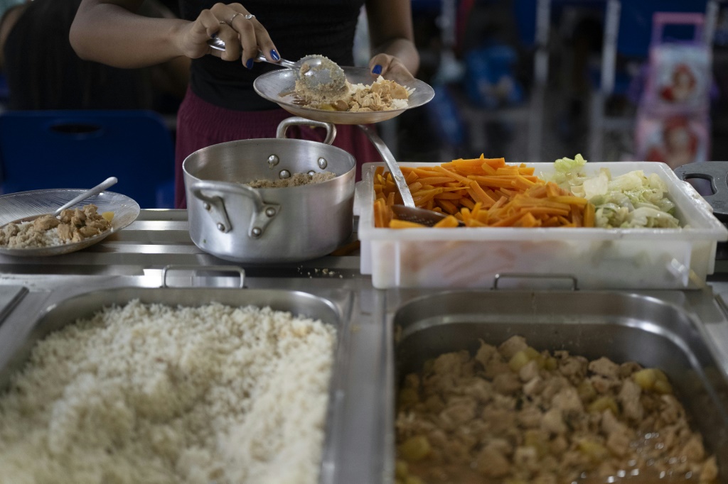 معلم يقدم وجبة الغداء في غرفة الطعام بمدرسة بورل ماركس في ريو دي جانيرو (ا ف ب)