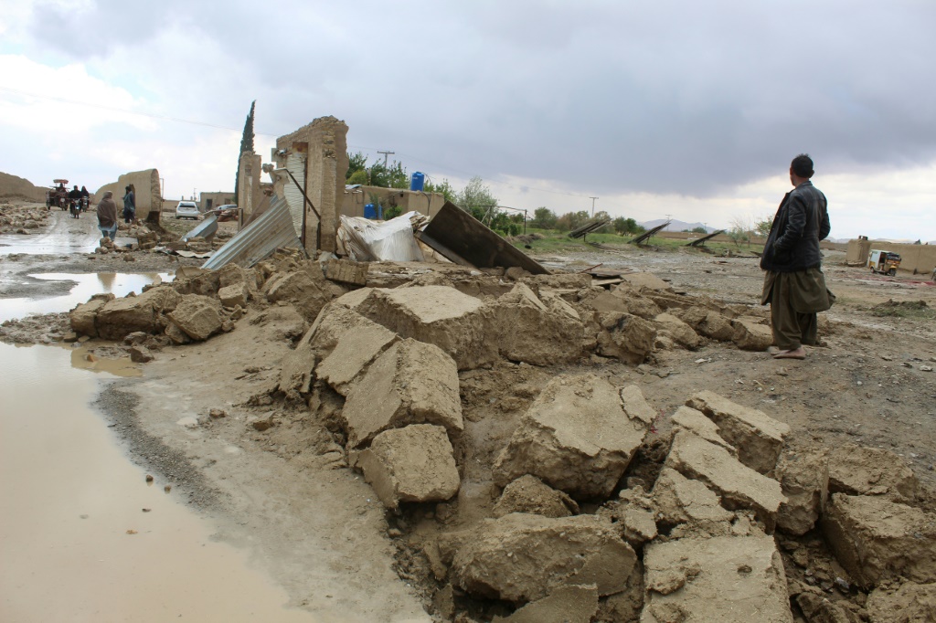 سكان يتجمعون قرب منزل متضرر جراء الأمطار الغزيرة في محافظة بلوشستان الباكستانية في 19 نيسان/أبريل 2024. (أ ف ب)   