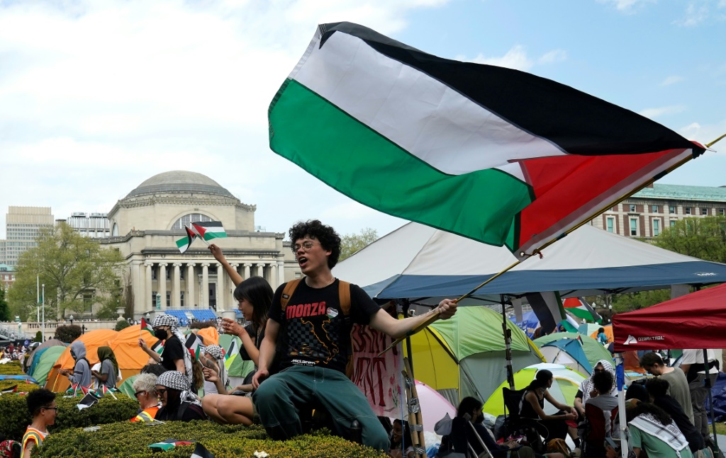 طلاب يرفعون علما فلسطينيا في جامعة كولومبيا في نيويورك بشرق الولايات المتحدة احتجاجا على الحرب في قطاع غزة في 30 نيسان/أبريل 2024 (ا ف ب)