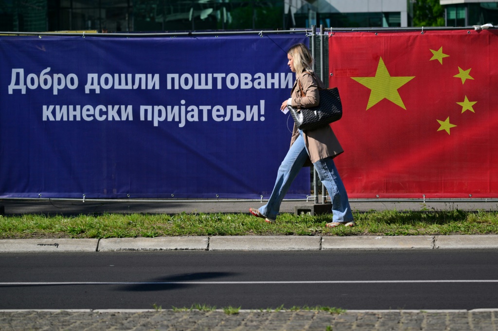 العلم الصيني ولافتة كتب عليها "مرحبا بالأصدقاء الصينيين الأعزاء" في بلغراد بتاريخ 7 أيار/مايو 2024 (ا ف ب)