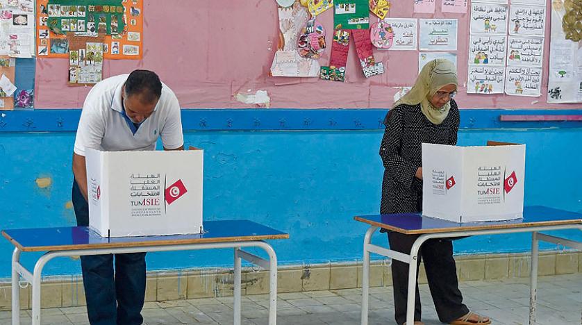 ناخبان يدليان بصوتيهما داخل مركز اقتراع في قرب العاصمة التونسية (أ.ف.ب)