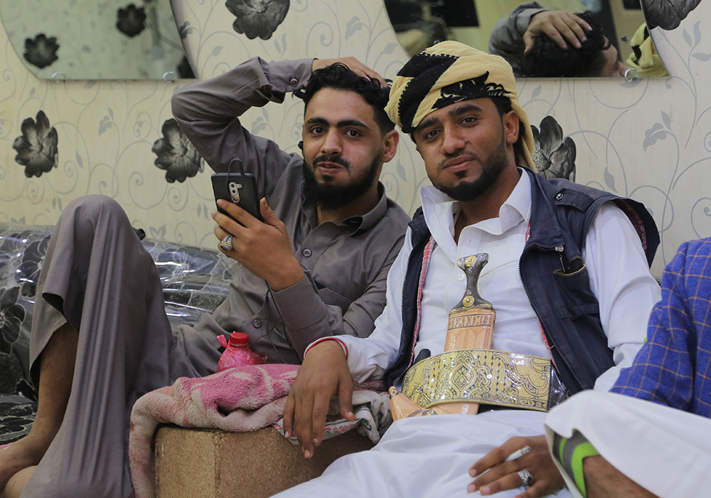 رجال يمنيون يمضغون القات (وهو نبتة منشّطة أشبه بالكوكا) في صالون حلاقة محلّي.
