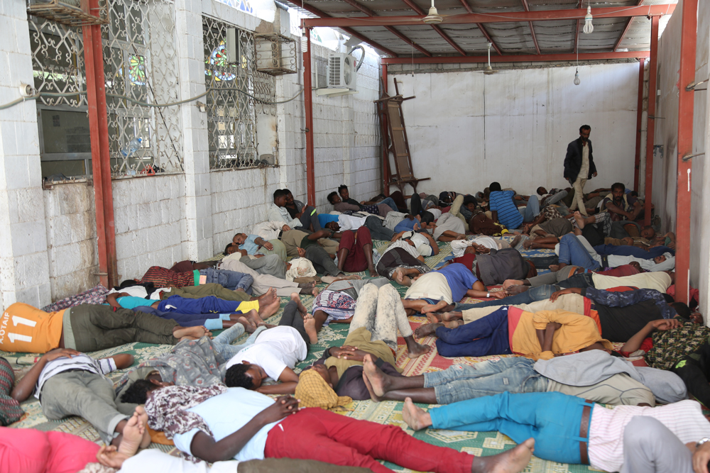 مهاجرون أفارقة ينامون في مساحة صغيرة عند مدخل أحد المساجد.