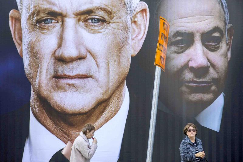 Widening chasm. People walk by an election campaign billboard for the Blue and White alliance, the opposition party led by Benny Gantz (L) in Ramat Gan, Israel. Prime Minister Binyamin Netanyahu of the Likud party is pictured on the right. (AP)
