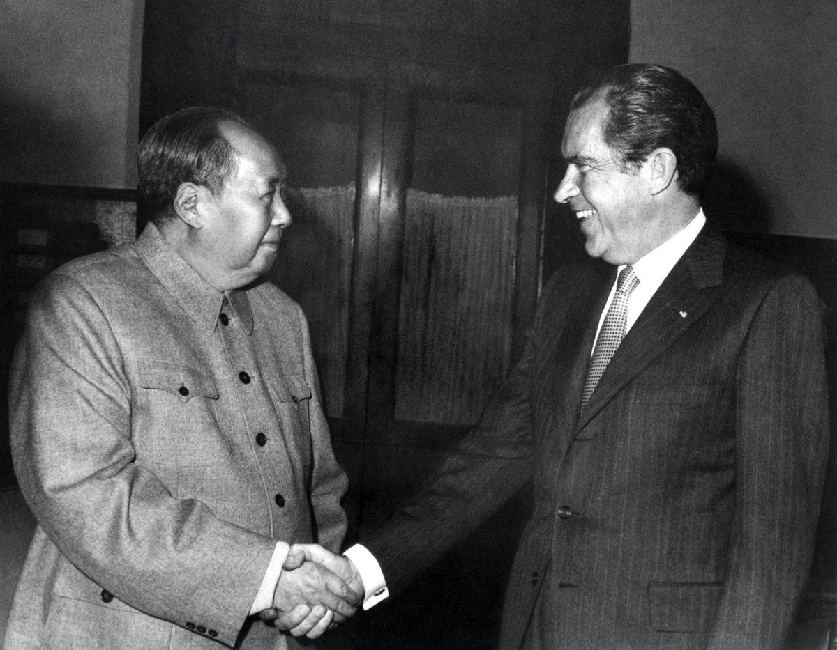 الرئيس الأميركي ريتشارد نيكسون والزعيم الصيني ماو تسي تونغ يتصافحان في بكين - 22 فبراير 1972 - AFP