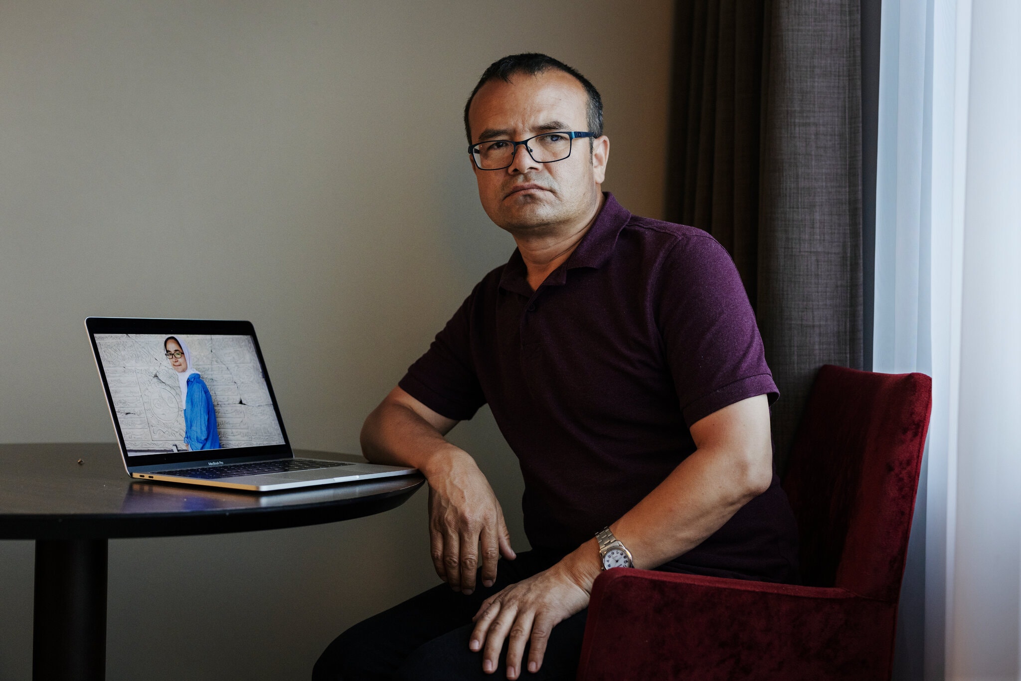 الناشط الإيغوري أيوب ويعرض على حاسوبه صورة ابنه أخيه التي توفيت في الصين