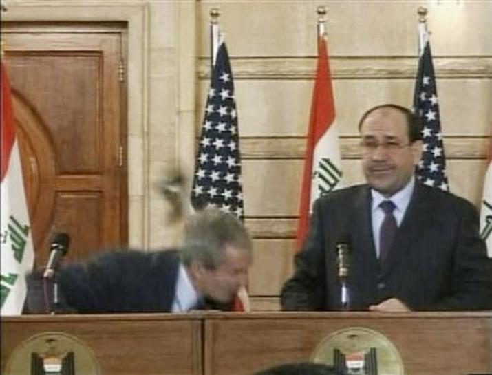 جورج بوش خلال تعرضه لمحاولة قذف بحذاء من قبل مواطن عراقي غاضب من قراره غزو العراق