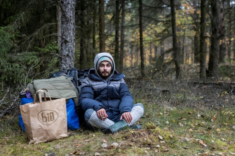 اللبناني علي عبد الوارث (24 عاماً) يجلس في غابة على الحدود البولندية البيلاروسية في 22 أكتوبر2021(ا ف ب)
