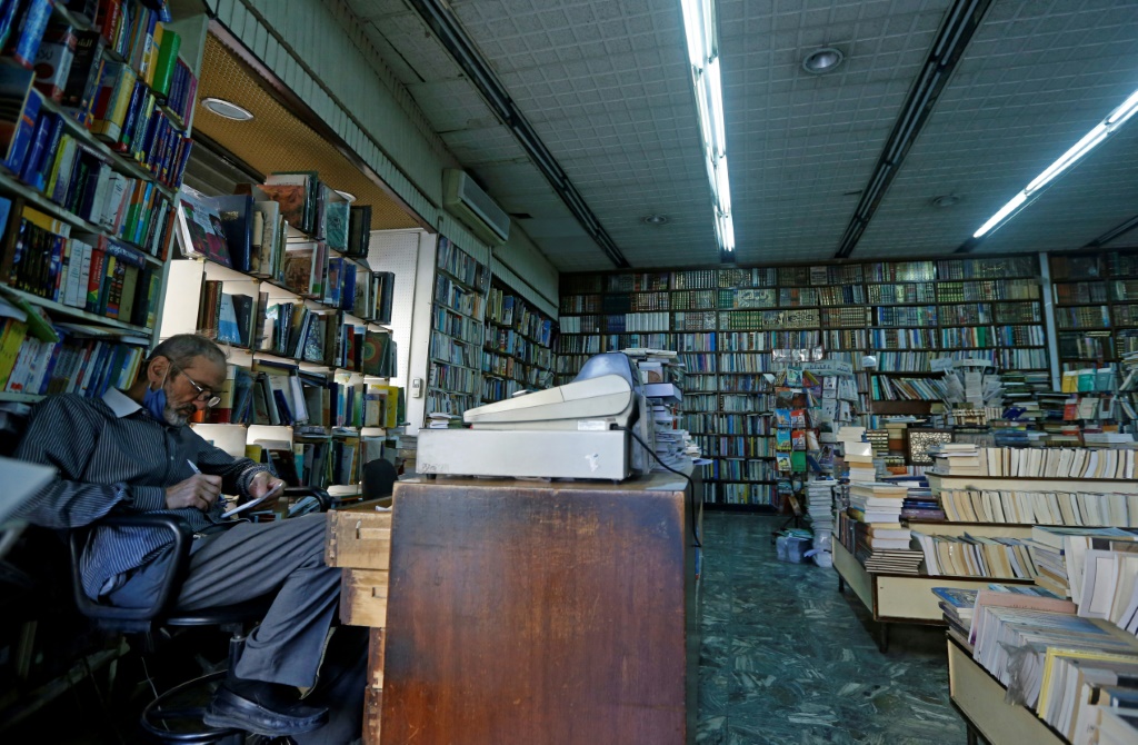 موظف يتفحص الكتب في مكتبة النوري في العاصمة السورية دمشق في 17 تشرين الأول/أكتوبر 2021(اف ب)