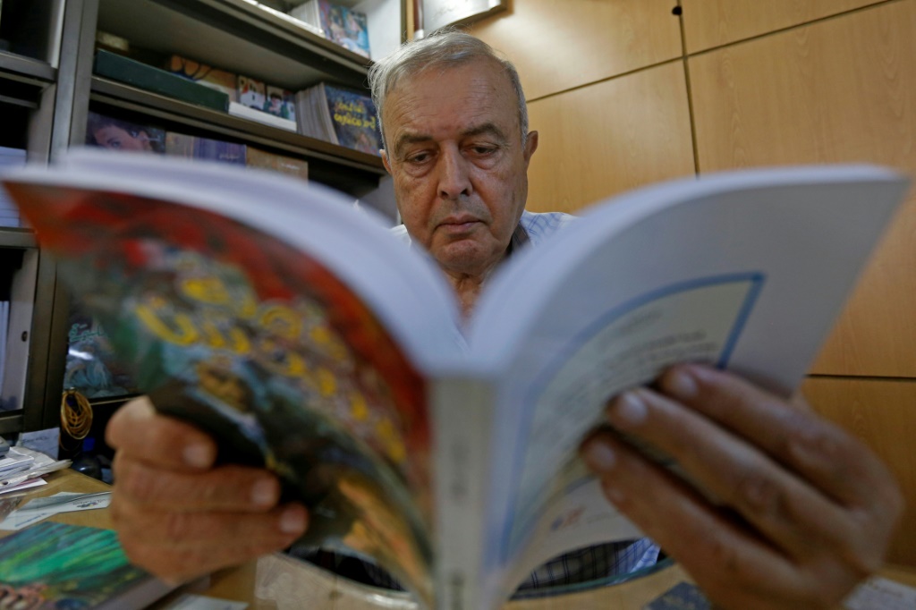 خليل حداد يقرأ كتابا في مكتبة دار أسامة للنشر والتوزيع في العاصمة السورية دمشق في 12 تشرين الأول/أكتوبر (اف ب)