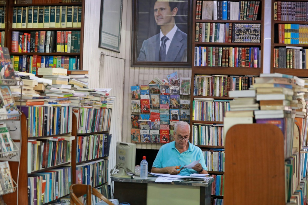 موظف يعمل في مكتبة النوري المهددة بالإغلاق والعائد تاريخ تأسيسها إلى سنة 1930، في دمشق في 17 تشرين الأول/أكتوبر 2021 (اف ب)