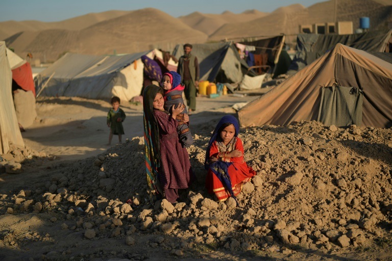 الطفلة أشو التي بيعت إلى رجل يبلغ 23 عاماً تجلس أمام خيمة في مخيم للنازحين في قلعة نو في إقليم باغديس في أفغانستان في 14 تشرين الأول/أكتوبر 2021(ا ف ب)