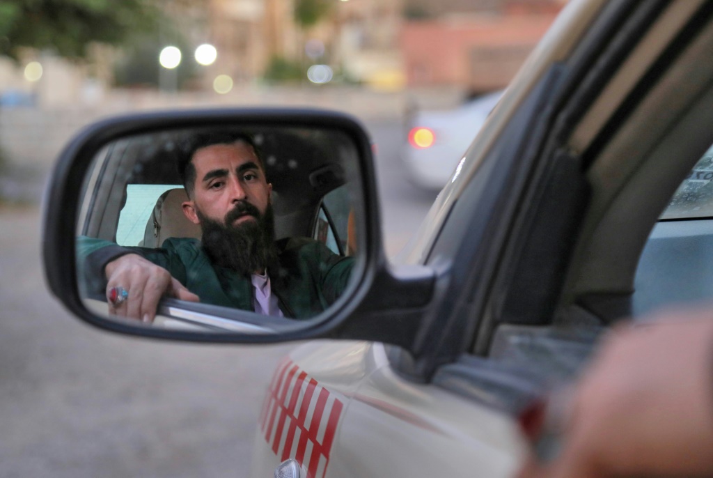 العراقي هيمن جبرائيل سائق تاكسي في كردستان العراق يريد الهجرة الى أوروبا في سيارته في إربيل في التاسع من تشرين الثاني/نوفمبر 2021 (أ ف ب)