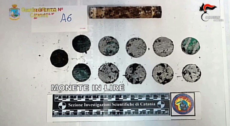 النقود المعدنية التي عُثر عليها مع الجثة المكتشفة داخل كهف في بركان إتنا في سبتمبر 2021(ا ف ب)