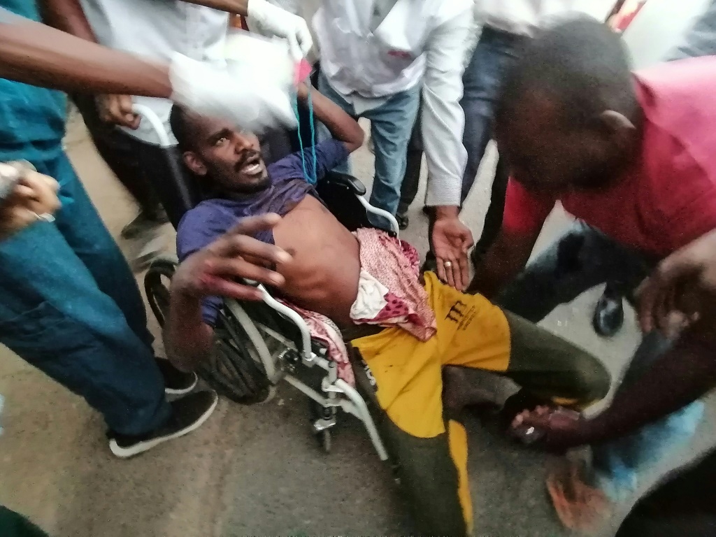متظاهرون سودانيون يحملون رجلا مصابا خلال احتجاجات ضد الانقلاب العسكري في ضواحي العاصمة الخرطوم في 13 تشرين الثاني/نوفمبر 2021 (ا ف ب)   