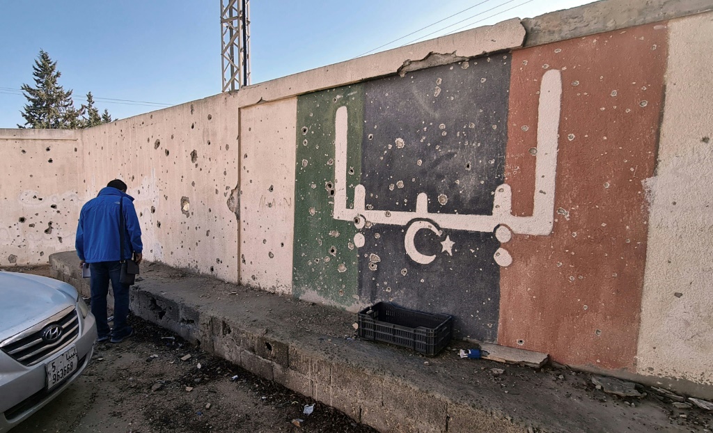 متطوع ليبي خلال أعمال إعادة ترميم مدرسة تضررت جرّاء القتال في إحدى ضواحي طرابلس بتاريخ 19 تشرين الثاني/نوفمبر 2020 (أ ف ب)   