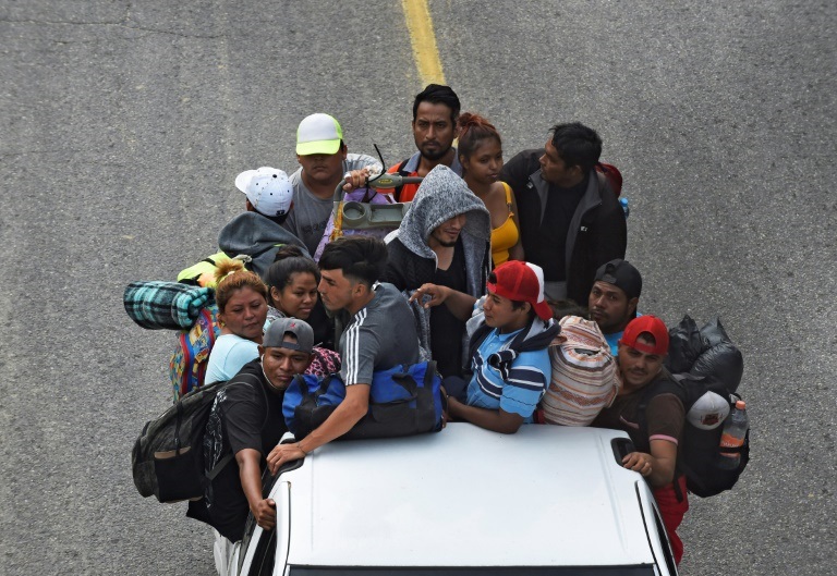 مهاجرون يتوجهون في قافلة إلى الولايات المتحدة، يركبون على ظهر شاحنة في إل أرينال، المكسيك، في 18 نوفمبر/تشرين الثاني 2021(ا ف ب)