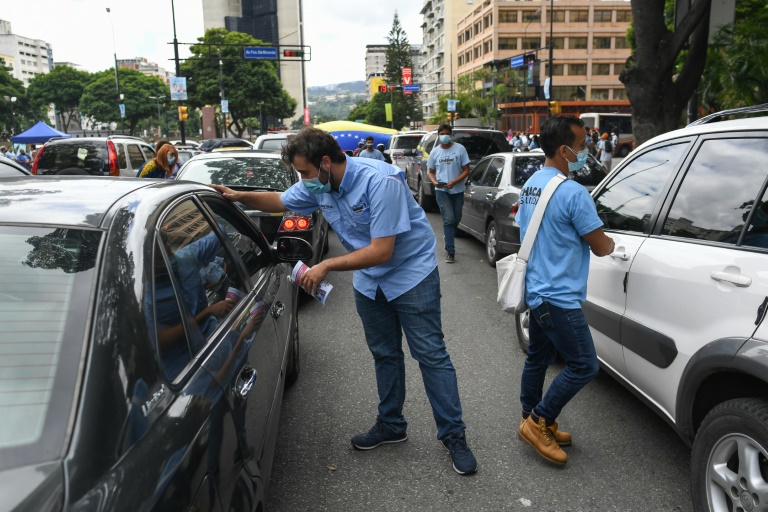   ناشطون في المعارضة يوزعون منشورات في الشوارع قبل الانتخابات البلدية في فنزويلا في 28 تشرين الأول/اكتوبر 2021(اف ب)