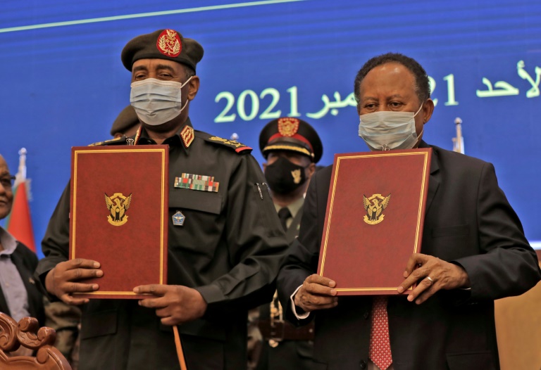 قائد الجيش السوداني، ورئيس الوزراء يعرضان الوثائق خلال مراسم توقيع الاتفاق الجديد (أ ف ب)