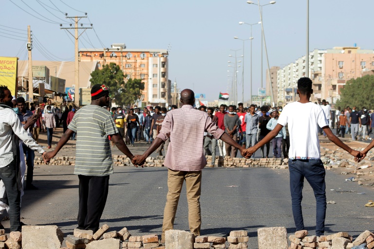 محامون سودانيون يرفعون لافتات تطالب بمحاسبة مرتكبي أعمال العنف ضد المتظاهرين أمام محكمة السودان العليا في العاصمة الخرطوم في 23 تشرين الثاني/نوفمر 2021(ا ف ب)