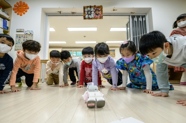 الروبوت "ألفا ميني" يعلّم حركات كونغ فو لأطفال يقلدونه ( ا ف ب)