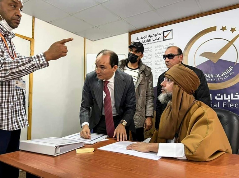    صورة وزعتها المفوضية العليا للانتخابات في ليبيا في 14 تشرين الثاني/نوفمبر 2021 تظهر سيف الإسلام القذافي وهو يقدم أوراق ترشحه الى الانتخابات الرئاسية في سبها في جنوب البلاد(ا ف ب)