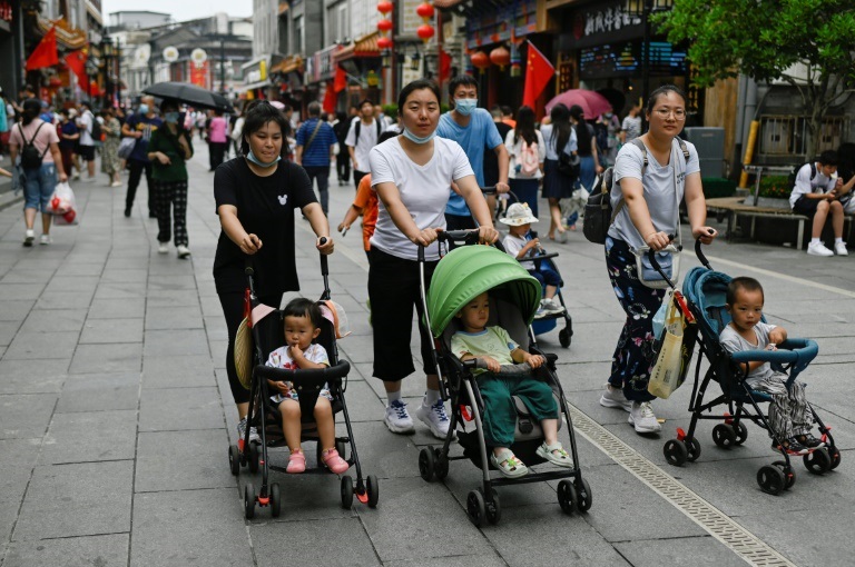 ثلاث نساء يسرن مع عربات أطفال في بكين في 13 تموز/يوليو 2021( ا ف ب)