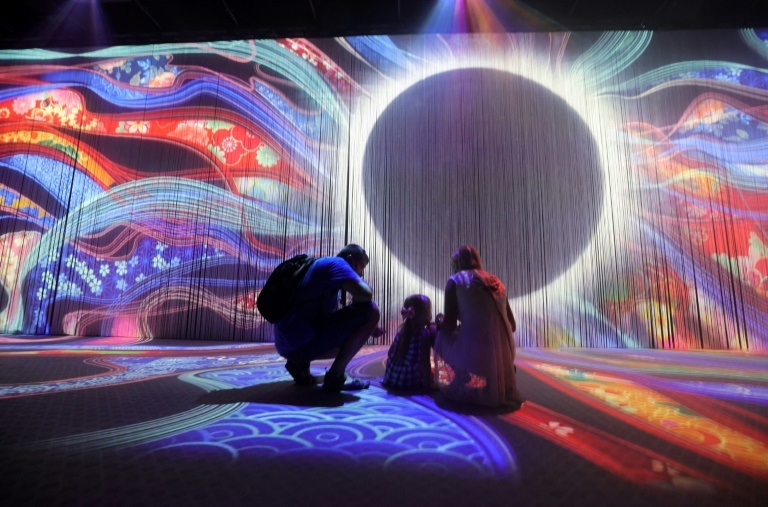 زوار يشاهدون عرضًا جداريا متحركًا داخل الجناح الياباني في معرض إكسبو 2020 بإمارة بدبي في 1أكتوبر2021(ا ف ب)
