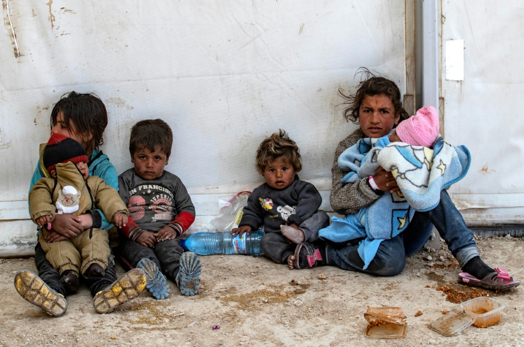 أطفال يجلسون على الأرض في مخيّم الهول في سوريا في 18 آذار/مارس 2021 (أ ف ب)