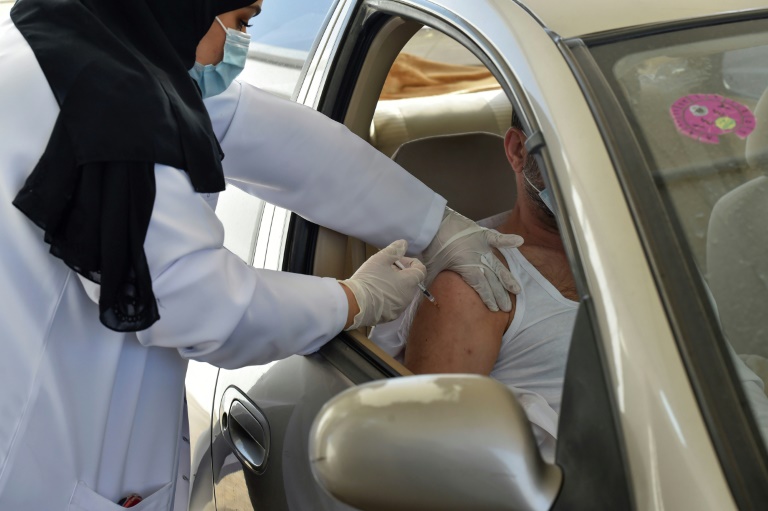 عاملة في طاقم طبي تعطي جرعة من لقاح استرازينيكا المضاد لفيروس كورونا في مركز تلقيح في العاصمة السعودية الرياض في الرابع من آذار/مارس 2021(ا ف ب)