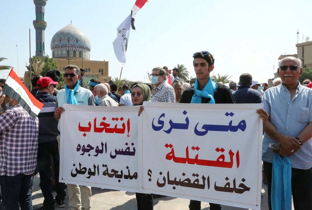 عراقيون يرفعون لافتات في ساحة الفردوس وسط بغداد في 1 تشرين الأول/أكتوبر 2021 للمطالبة بالعدالة لمتظاهرين قُتلوا خلال الاحتجاجات المناهضة للطبقة السياسية في خريف 2020 وذلك قبل الانتخابات البرلمانية في 10 تشرين الأول/أكتوبر (ا ف ب)   