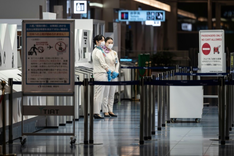 موظفات يقفن في جهة المغادرة في مطار طوكيو الدولي في 29 نوفمبر 2021 ( ا ف ب )