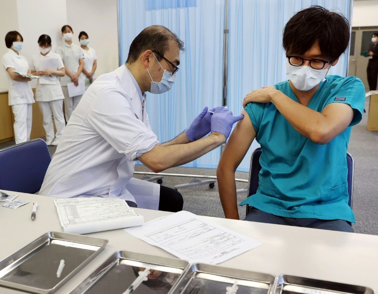 رجل (يمين الصورة) يتلق جرعة ثالثة من اللقاح المضاد لكوفيد-19 في المركز الطبي في طوكيو في اليابان في الأول من كانون الأول/ديسمبر 2021 ( ا ف ب )
