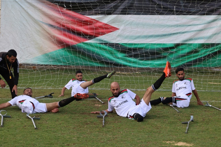 لاعبون فلسطينيون من المنتخب الفلسطيني الوطني لكرة القدم لذوي البتر خلال مباراة تدريبية تحت إشراف اللجنة الدولية للصليب الأحمر في الثاني من كانون الأول/ديسمبر 2021 في ملعب فلسطين في قطاع غزة المحاصر ( ا ف ب )