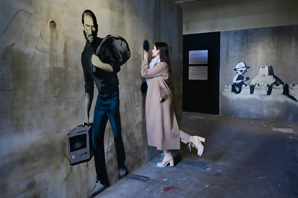 صورة التقطت في 2 كانون الأول/ديسمبر 2021 للوجة جدارية لبانكسي تمثل ستيف جوبز ضمن معرض "عالم بانكسي" في محطة ميلانو للقطارات (ا ف ب)   